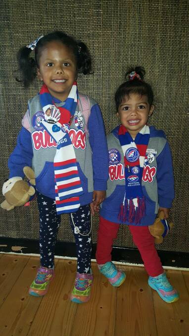 Alira, with sister Sadie, shows her colours before an AFL game