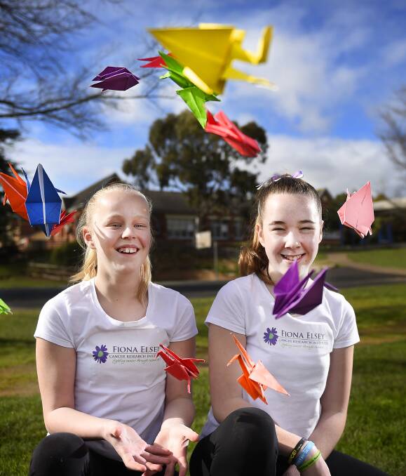 CREATING HOPE: Japanese class has Buninyong primary pupils Phoebe Shaw and Lani Wallace thinking big on what difference they could make by folding 1000 paper cranes. Picture: Luka Kauzlaric