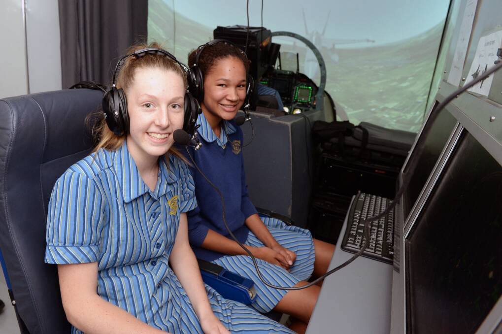 SET FOR TAKE-OFF: Loreto College year 10s Charlotte Todd and Indya Forde take up radar positions to help guide pilots on their mission in the RAAF flight simulator on Friday. Picture: Kate Healy