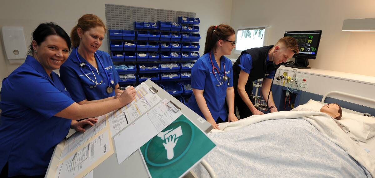 STUDY: Third-year nursing students Nicole Ford, Sue Trainor, Madelin Smith and Aidan Cooper care for a simulated patient. Picture: Lachlan Bence