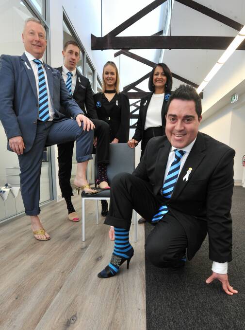 Harcourts' Peter Ludbrook, Tim Menz and Chahli Curwood-Hyde with Victorian chief executive officer Sadhana Smiles and Jason Gigliotti, testing out high heels for fundraising event Walk a Mile next month. Picture: Lachlan Bence
