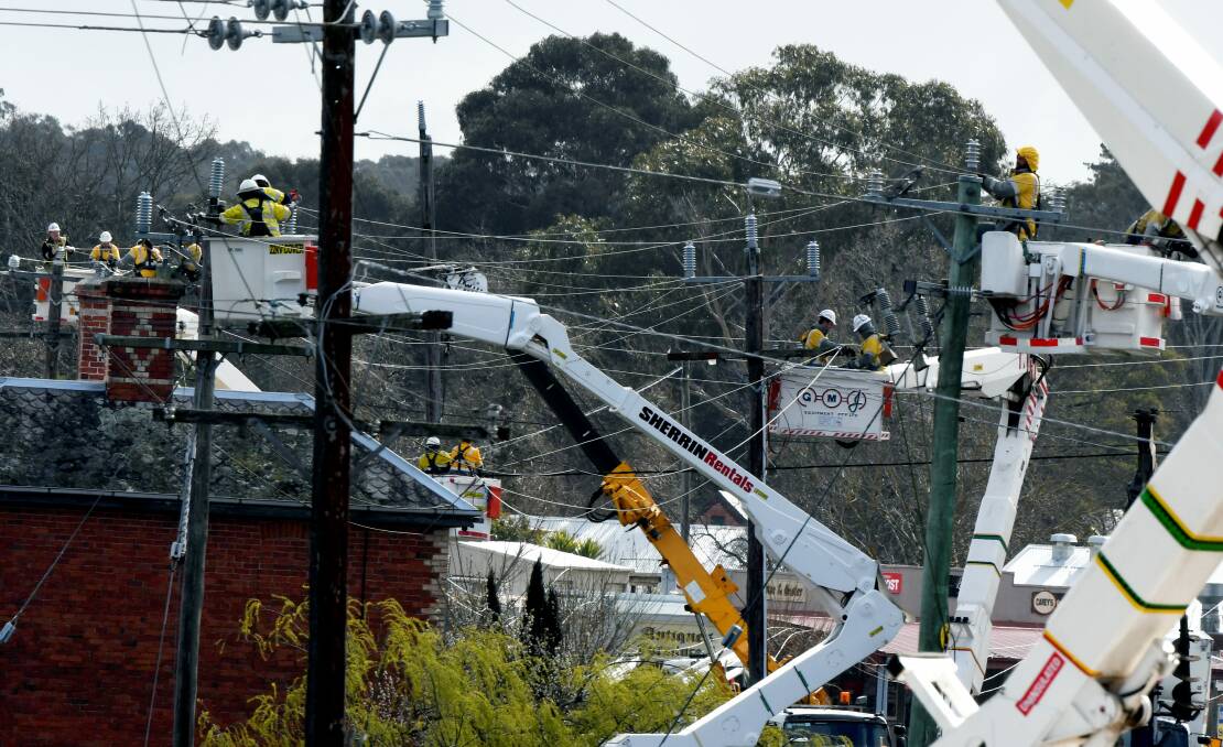 Tangled web: Workers perform a cross arm replacement, part of routine maintenance, at a power line which affected residents in Smythesdale and Scarsdale with a power outage on Tuesday. Picture: Lachlan Bence 