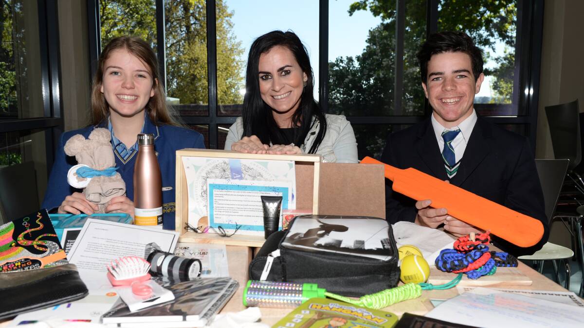 Giving: Loreto College student Daisy Kennington, Berry Street's Monica Solomon and St Patrick's College student Adam Svaljek. Thirty five students created support bags for children affected by family violence. Photo: Kate Healy