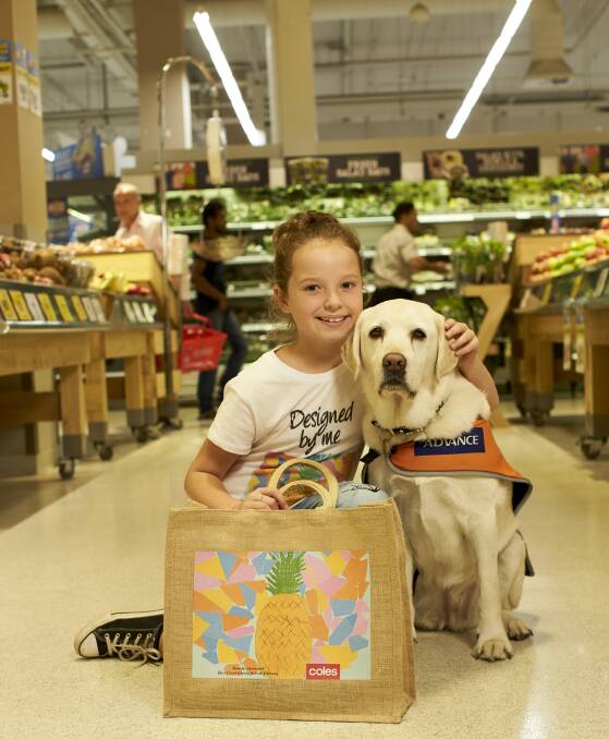 Green art: Nine-year-old Kassidy Jewell pictured with guide dog Willow and her bag design, which will raise money for Guide Dogs Australia. 