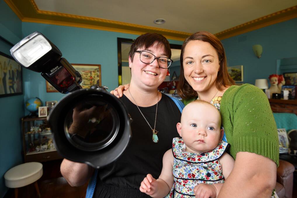 HAPPY FAMILY: Lesley Williams, left, and Megan Fromholtz with their daughter Clementine. The couple has won a national competition to have their wedding photographs taken for free. Picture: Dylan Burns