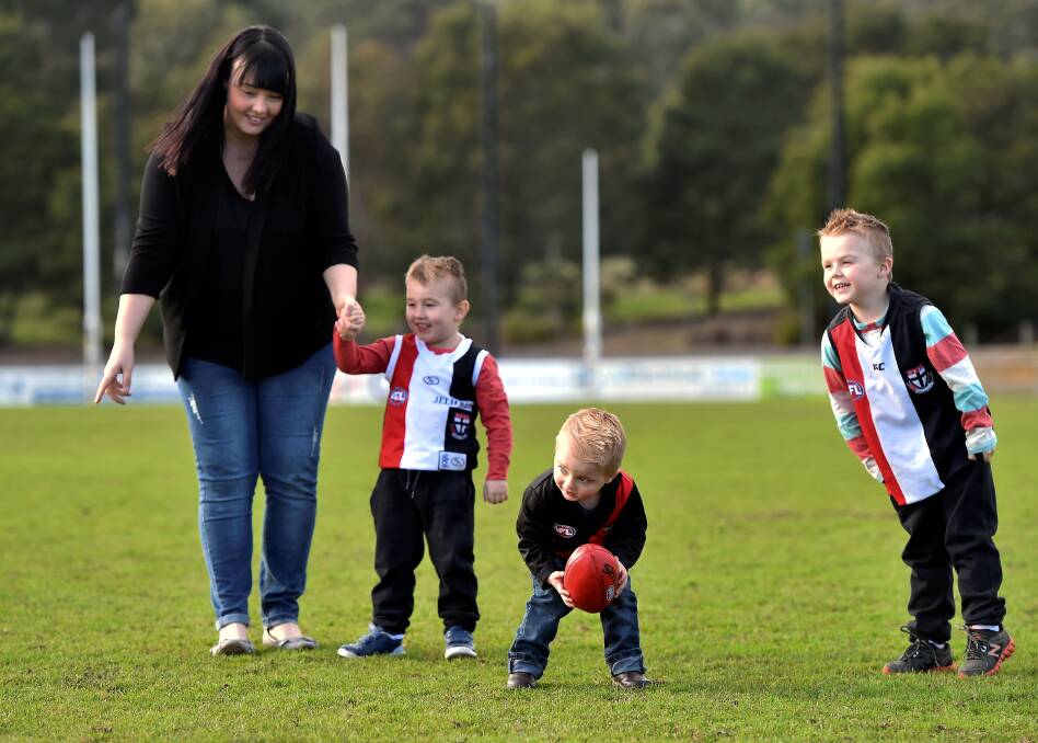 BROTHERS IN ARMS: Max, 5, Will, 4, and Hudson, 2, have a kick of the footy with mum Belinda. Picture: Jeremy Bannister