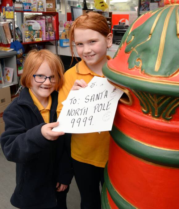 FESTIVE CHEER: Sophia Cheesman, 7, and Annabelle Cheesman, 9, post their letters to Santa at the Black Hill Post Office. Picture: Kate Healy
