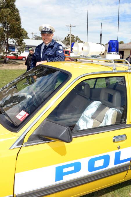 Cruising for a cause: Simon Murran and his historical police car joined dozens of hot rods on their journey along the Western Highway from Ararat to Bacchus Marsh on Saturday. Picture: Kate Healy 