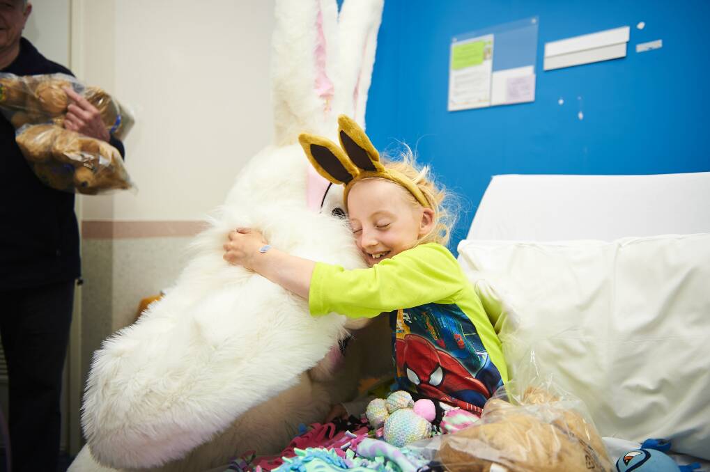 Welcome cuddle: Seven-year-old Sasha Mishkinis was all smiles after receiving a visit from the Easter Bunny at the Ballarat Base Hospital on Sunday morning. Picture: Luka Kauzlaric
