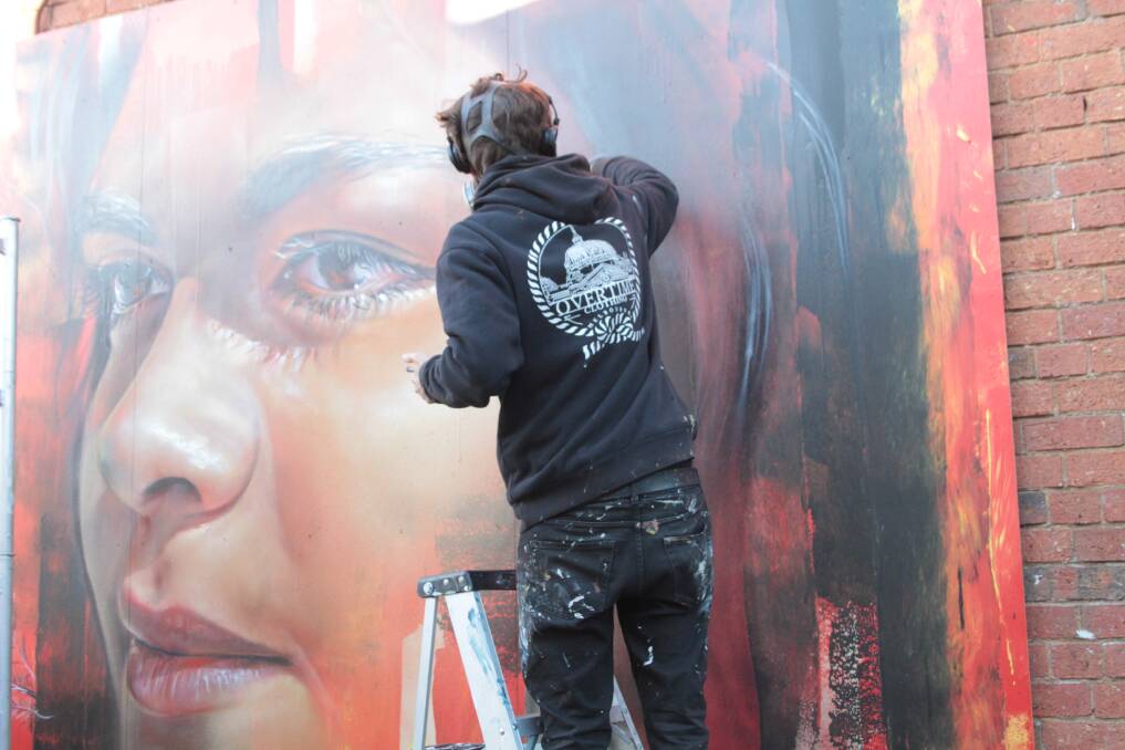 Drawcard: Renowned artist Adnate received plenty of attention for his mural of indigenous woman Akira Kelly in Trentham.  Picture: Richard Ryan. 