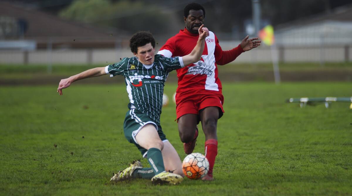 Sliding challenge: Forest Rangers' William Korner slides in an attempt to win the ball from Ballarat's Kossici Akakpo during Sunday's contest.  Picture: Luka Kauzlaric.