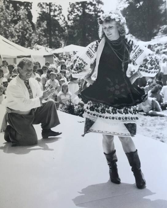 Vera Zylan dancing a traditional Ukrainian hopak at a demonstration in Ballarat in the 1980s. Her husband Richard is kneeling beside her.