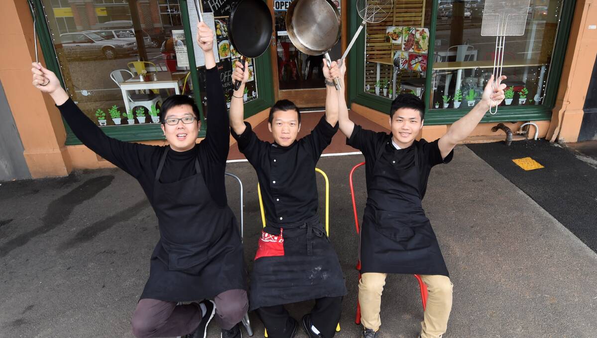 From rifles to rice: Ran Jin, Tony Gan and Oliver Woo outside their restaurant Free Time in Mair Street. Picture: Lachlan Bence.