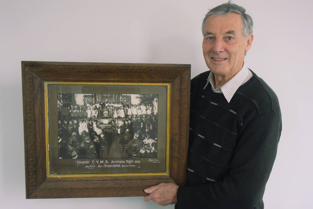 A Catholic tradition: Michael Taffe holds the photograph from 1920 featuring the banner recording donor's names from the Great War. Picture: Caleb Cluff.