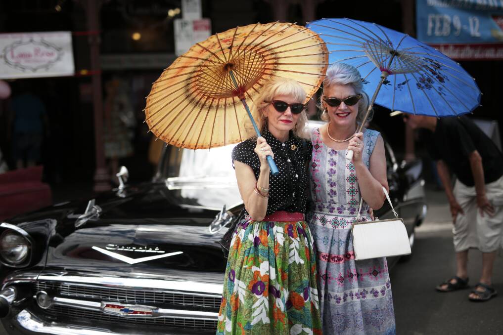 Parasols and prints: Dona Pentland and Nerida Williams in front of a black 1957 Chevrolet at the 2017 Ballarat Rockabilly Festival. The Show and Shine is always a big drawcard for the festival. Picture: Luka Kauzlaric.