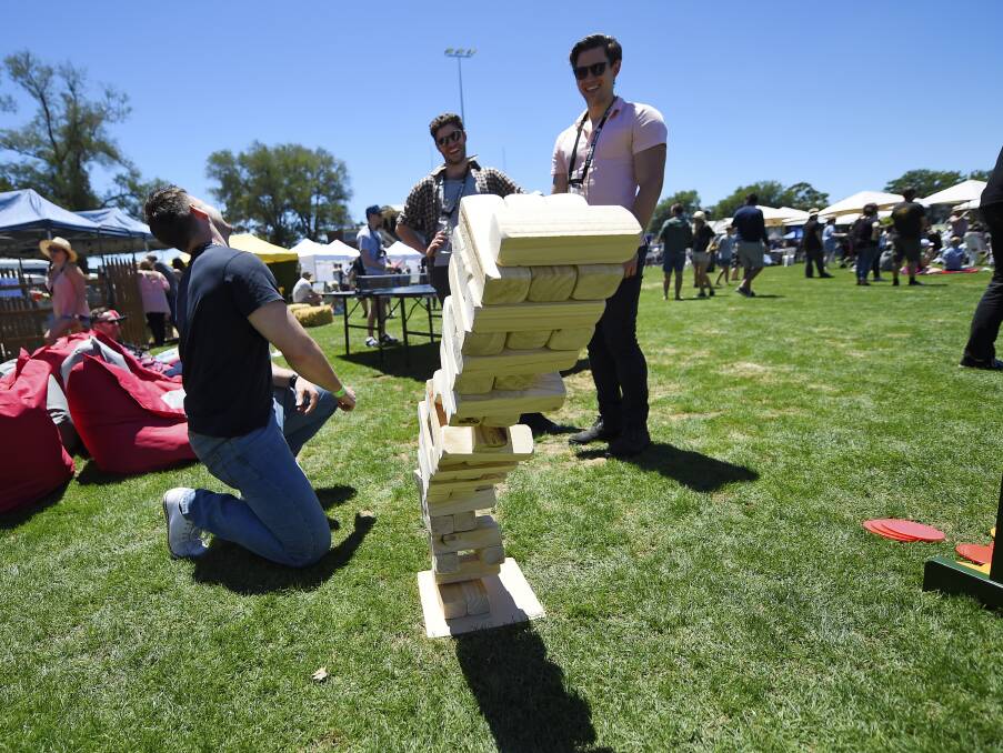 Jenga: Several life-size versions of the game were available around the Oval, testing patron's balancing skills as the day went on. Picture: Luka Kauzlaric.