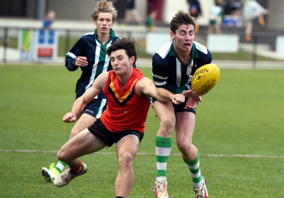 PUNCH: St Patrick's College's Scott Carlin looks to mark on his chest as a Ballarat Clarendon College fists spoils the ball. Pictures: Jeremy Bannister