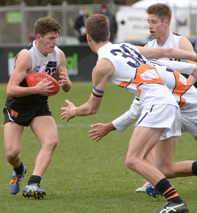 Lachlan Huppatz evades the clutches of his Calder Cannons opponents.