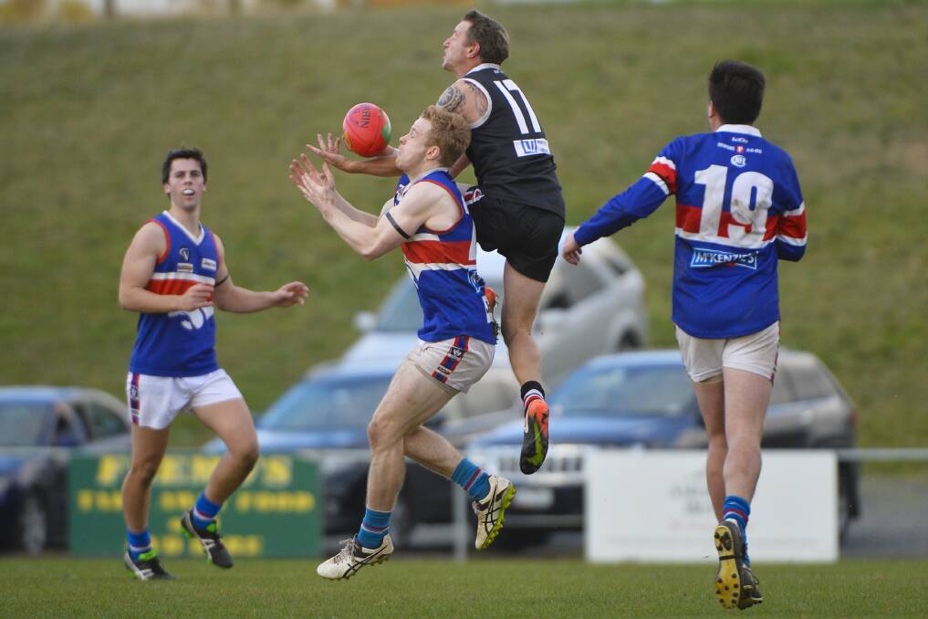 CONTEST: Daylesford's Patrick Rowe flies for the ball with Creswick's Paul Phillips on Saturday. Picture: Dylan Burns.