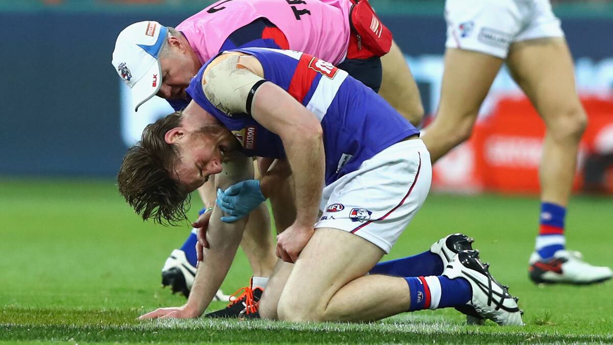 DOWNED: Roughead is attended to by a member of the Bulldogs' medical staff. Pictures: Getty Images.