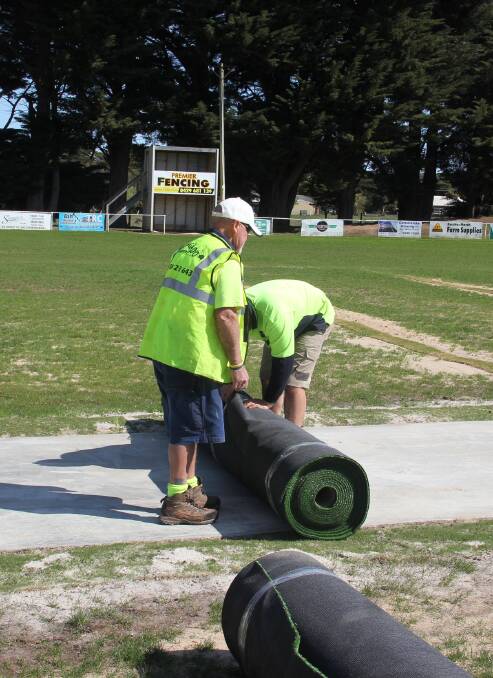 NEW PITCH: Workers roll out the new synthetic surface at Ballan.