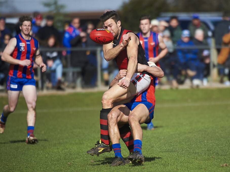 TACKLE: Buninyong ruckman Anthony Ebery gets a handball away despite pressure from a Hepburn opponent.
