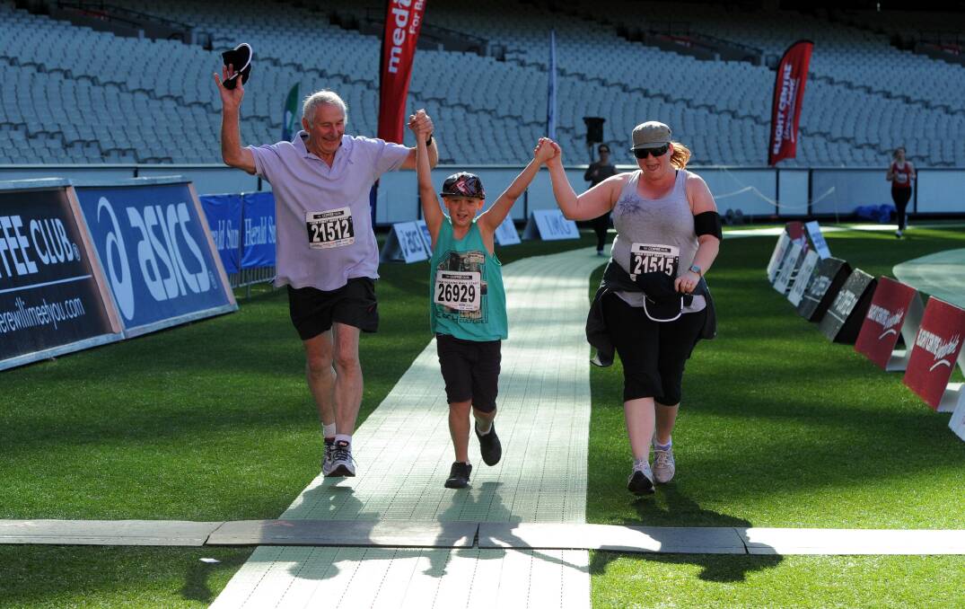 REWARD: Competitors celebrate crossing the finish line in the Melbourne Marathon festival at the MCG in a unique chance to feel the stadium from a different perspective. Picture: The Age