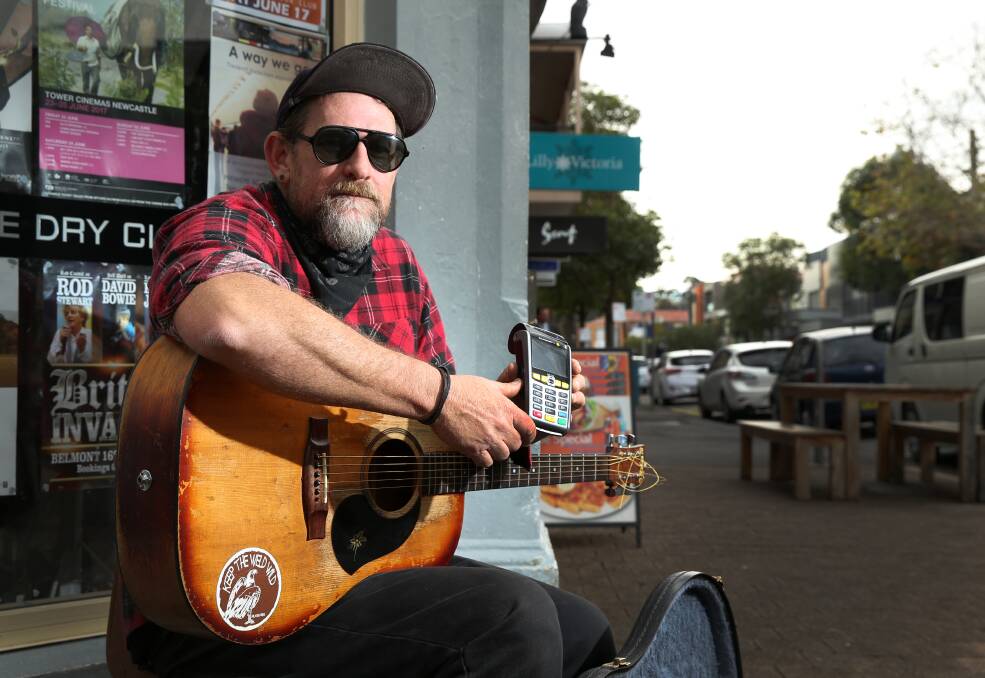 Money talks: Busker Tad Poe Dee in Darby Street, where he says his takings have dropped because people don't carry coins. Picture: Marina Neil. 