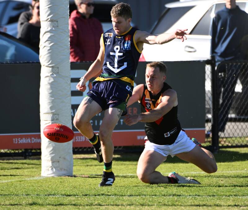 Bayley Thompson of Lake Wendouree gets his kick away despite pressure from behind. Picture by Lachlan Bence