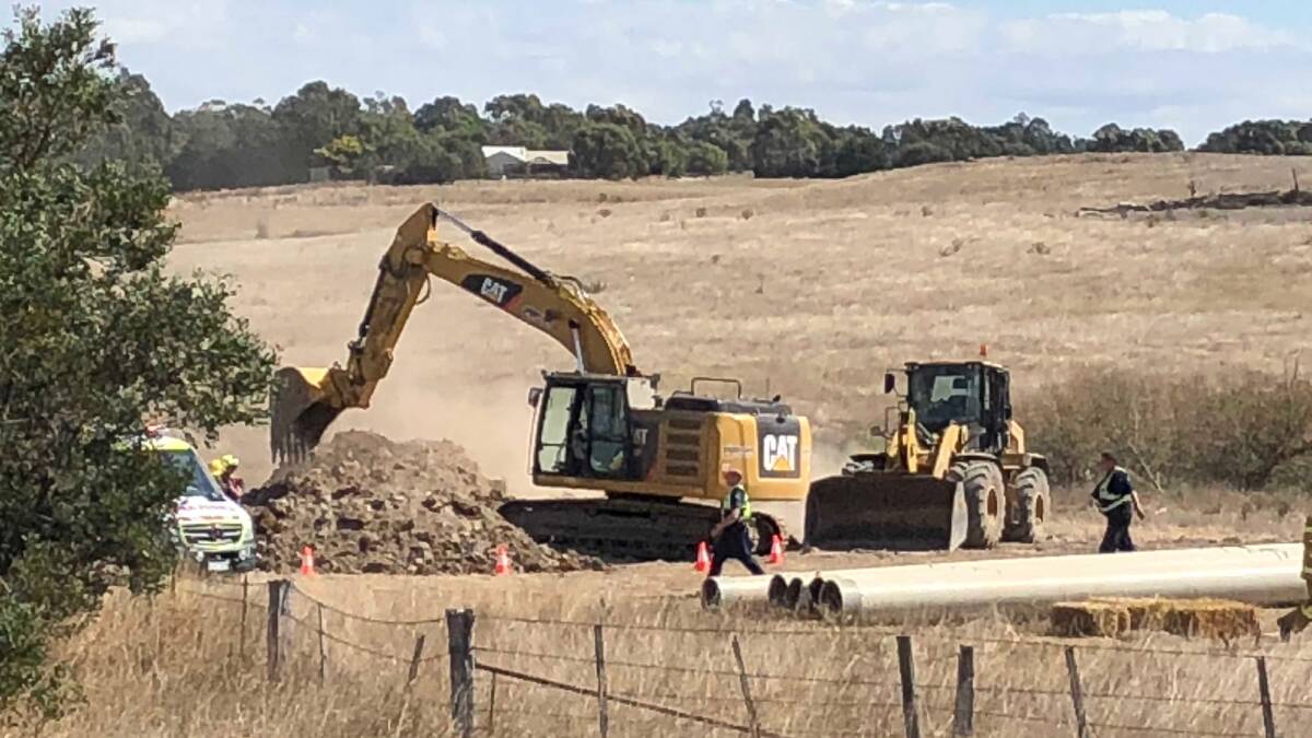 Earth moving equipment is brought in to help rescue a man trapped in a trench collapse in Delacombe today. Picture: Greg Gliddon