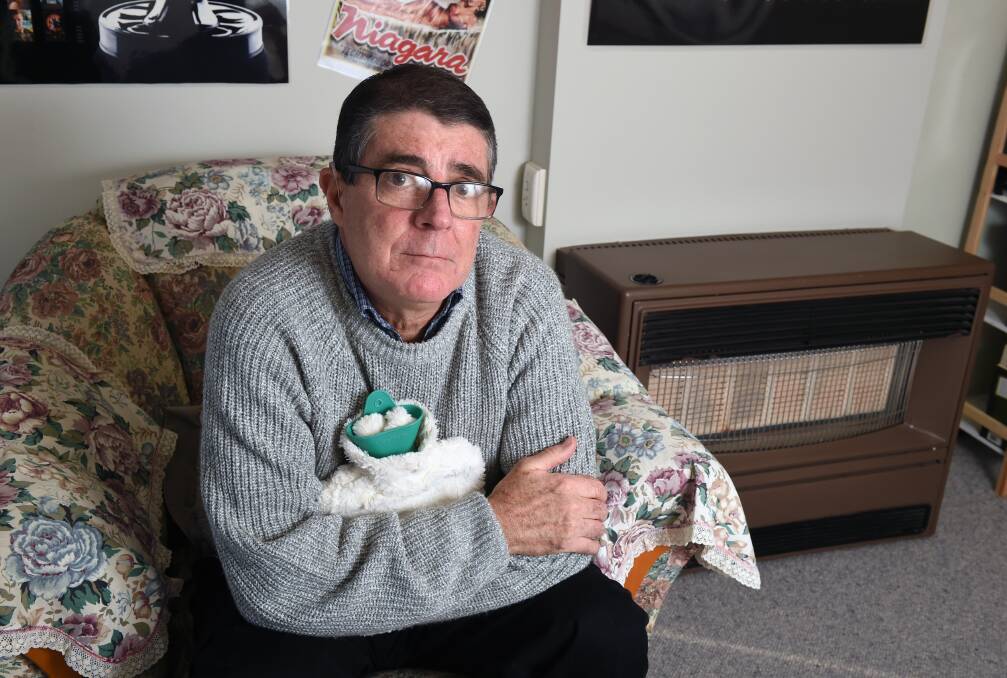 COLD: Russell Mangion relies on his hot water bottle while he waits for his faulty Vulcan heater to be replaced. Picture: Kate Healy