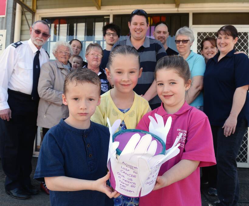 Helping hand: Archie and Lily Borchers, with cousin Sophie Moody are surrounded by family and their father Justin (back middle). A trust fund has been set up to support the children following the death of their mother Michelle.