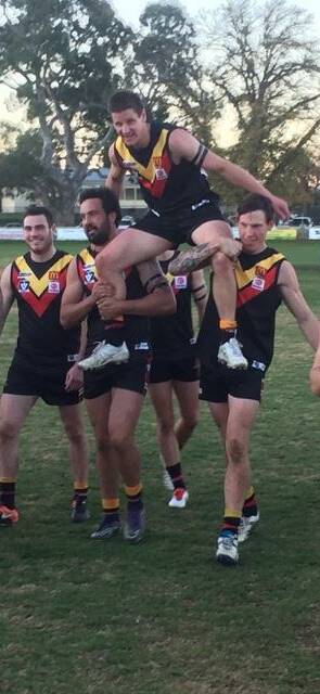 RIDING HIGH: Dean Heta and Rhys McNay chair off Daniel Velden to mark his 250th senior appearance with Bacchus Marsh against Lake Wendouree. Alec del Papa is pictured left.