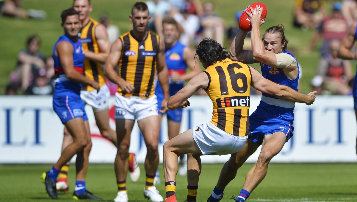 GOTCHA: Mitch Honeychurch (Western Bulldogs) does his best to avoid tackling attempt by Hawthorn's Isaac Smith. 