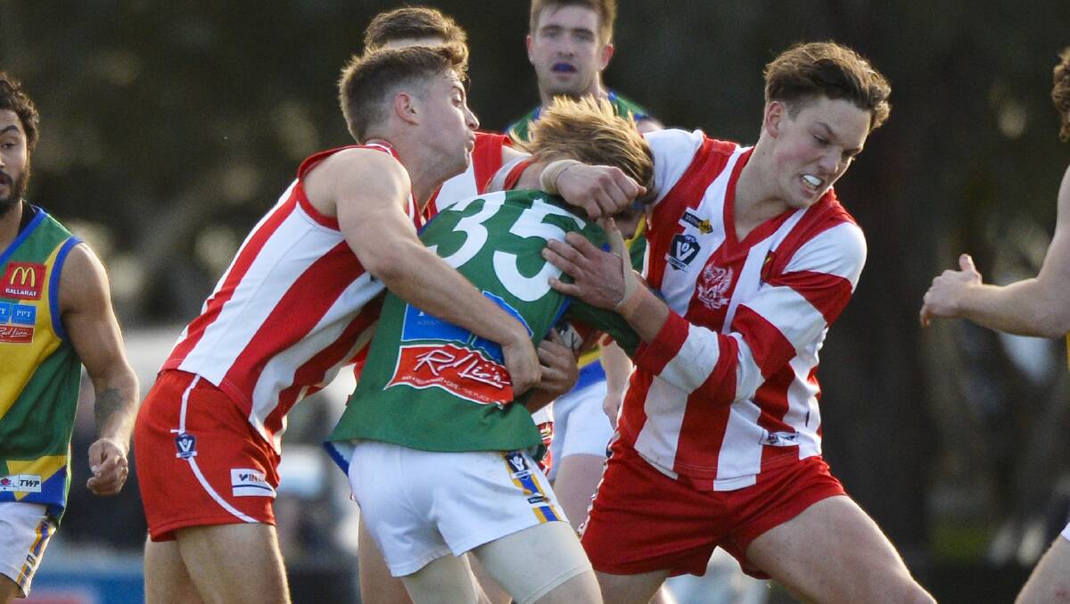 Ballarat defender Bailey Van De Heuvel catches Lakers' Kynan Raven high, while Grant Baldwin lays a more conventional tackle. Picture: Dylan Burns