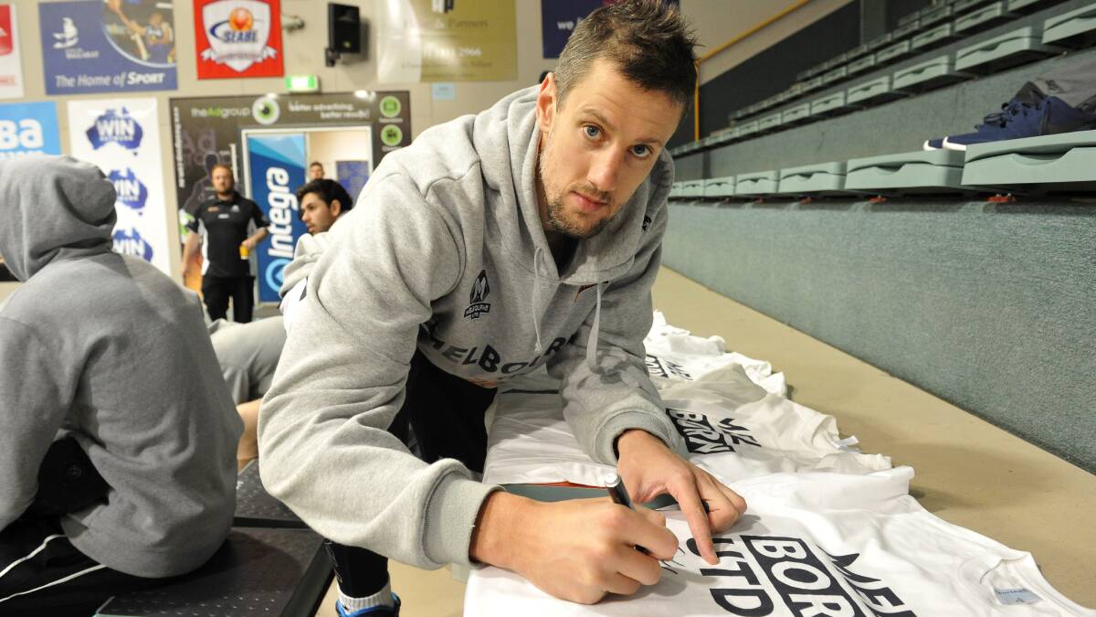 MELBOURNE United's Daniel Kicker signs T-shirts in readiness for Saturday night's NBL pres-season game against Cairns Taipans at the Minerdome. Picture: Lachlan Bence