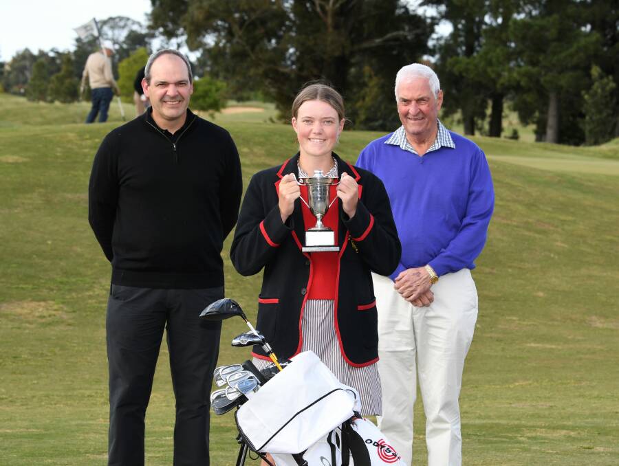 FAMILY GOLF DYNASTY: Sophie Byrne shows off her championhip trophy, flanked by   uncle Ross Titheridge and grandfather Neil Titheridge. Picture: Lachlan Bence