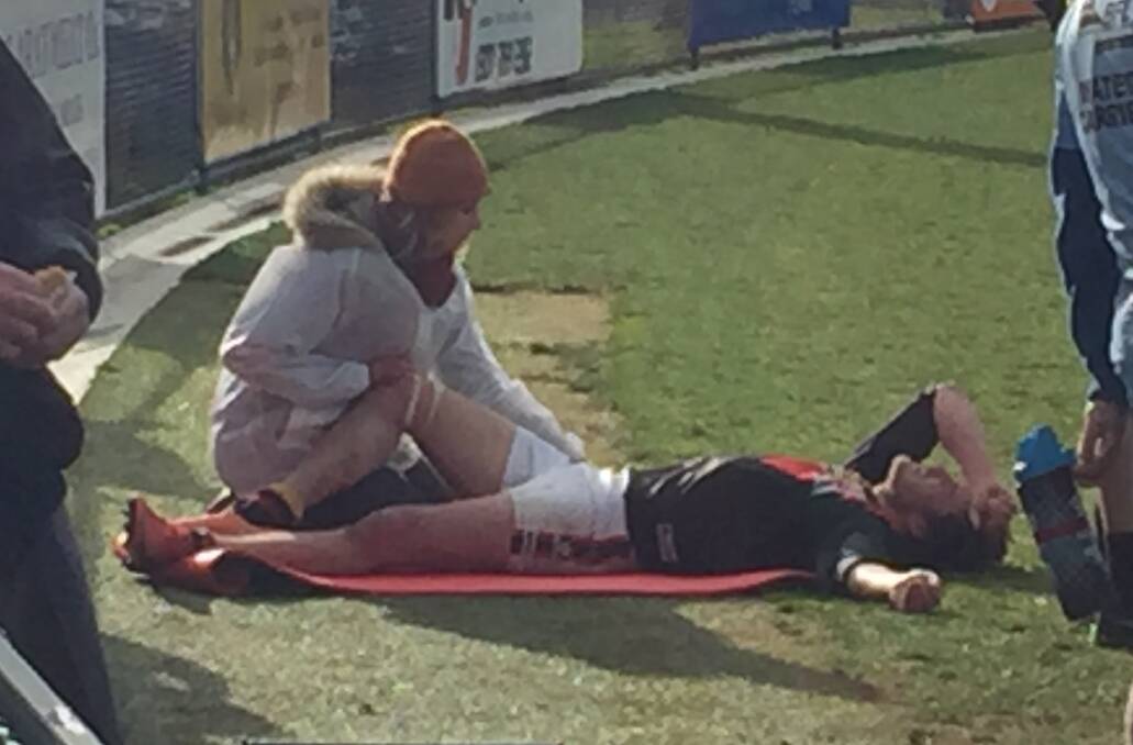 Bacchus Marsh's Cam Richardson is treated after taking a heavy knock against Lake Wendouree