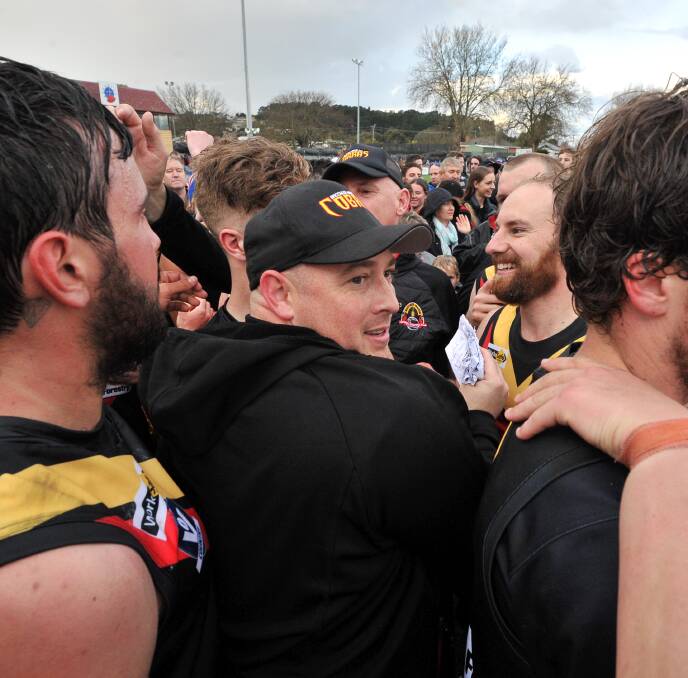 SWAMPED: Bacchus Marsh coach Travis Hodgson gets among his players in on-field celebrations.