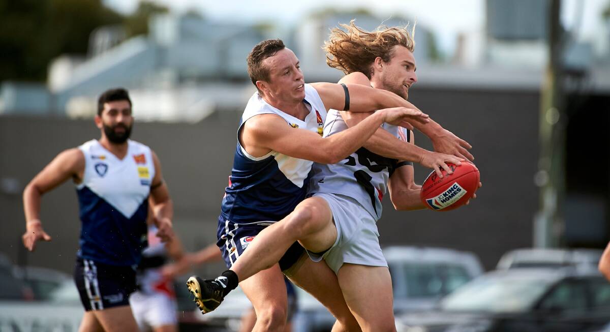 KEEN AFFAIR: Melton South captain Shaun White and North Ballarat City's Martin Curtis get in a tangle in this contest for possession. Picture: Luka Kauzlaric