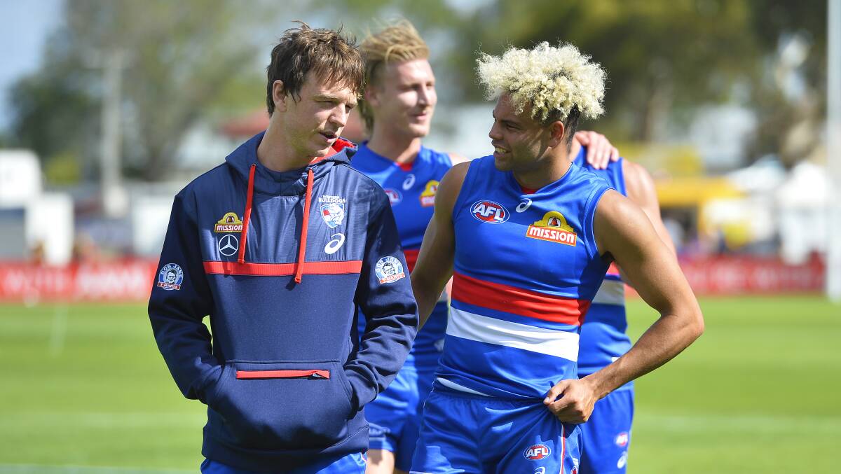 Jason Johannisen chats with teammate Liam Picken, who suffered suspected concussion, on the ground after the match.