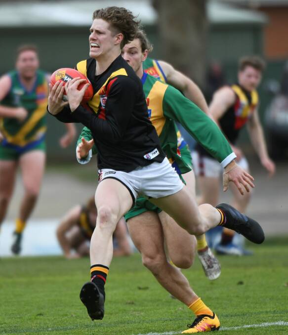 IN FRONT: Bacchus Marsh forward/midfielder Hamish Coulton is rewarded for hard running with a mars in front of Lake Wendouree's Nathan Monk