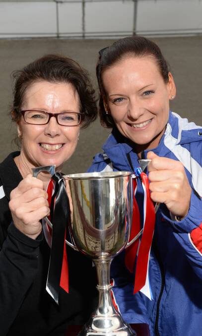 Heavyweights: North Ballarat City coach Annie McCartin and East Point coach Sascha Veldhuis get a feel for the premiership cup.  Picture: Kate Healy.  