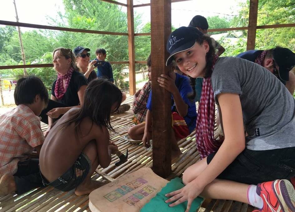 BUILDING: Lauren McKenzie spends time with children from the family she helped build a house for in Cambodia on a life-changing trip to the country in 2015.  