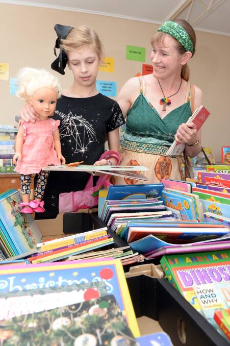 BOOK SALE: Monique Allain, 12, and Suzanne Allain from Langwarrin with Italia the doll check out the reading material at the UnitingCare Book Fair. Pictures: Kate Healy.