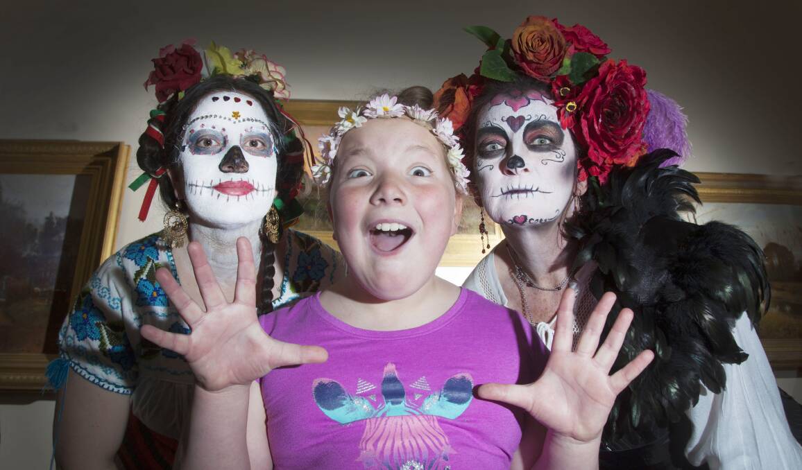 LA CATRINAS: Catherine Toro and Christine Crawshaw surprise Amy, 10, with their traditional Mexican skull-faced makeup to mark the upcoming Romancing the Skull exhibition at the Art Gallery of Ballarat. Picture: Mark Smith