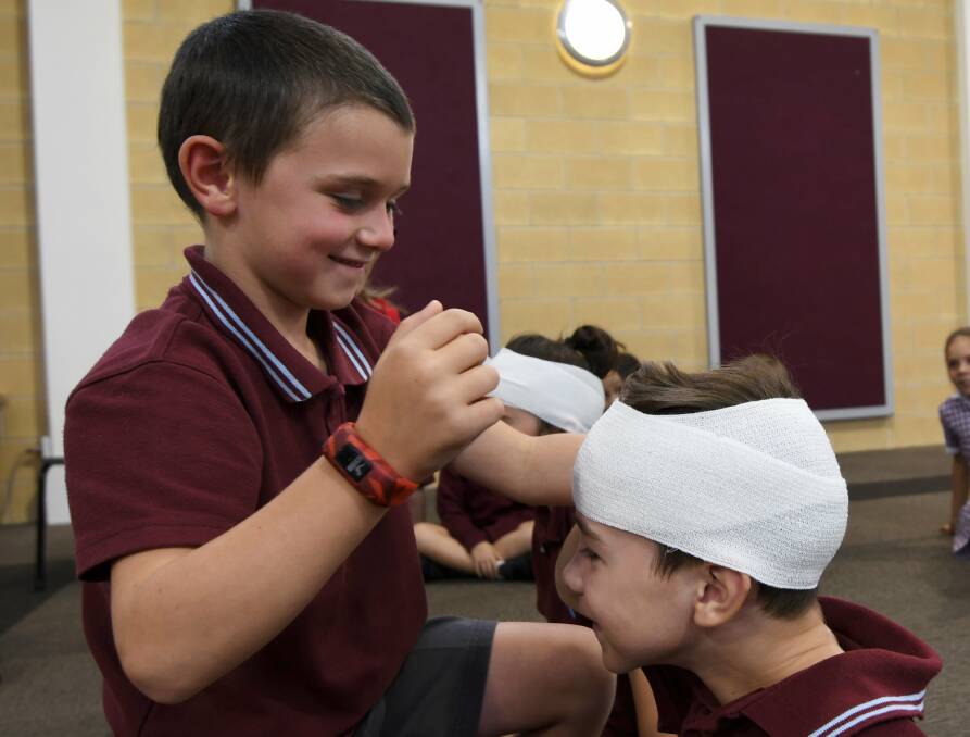 FIRST AID: Grade one student Fletcher practices bandaging grade two student Luke during St John Ambulance first aid training at St Alipius Parish Primary School. Picture: Lachlan Bence