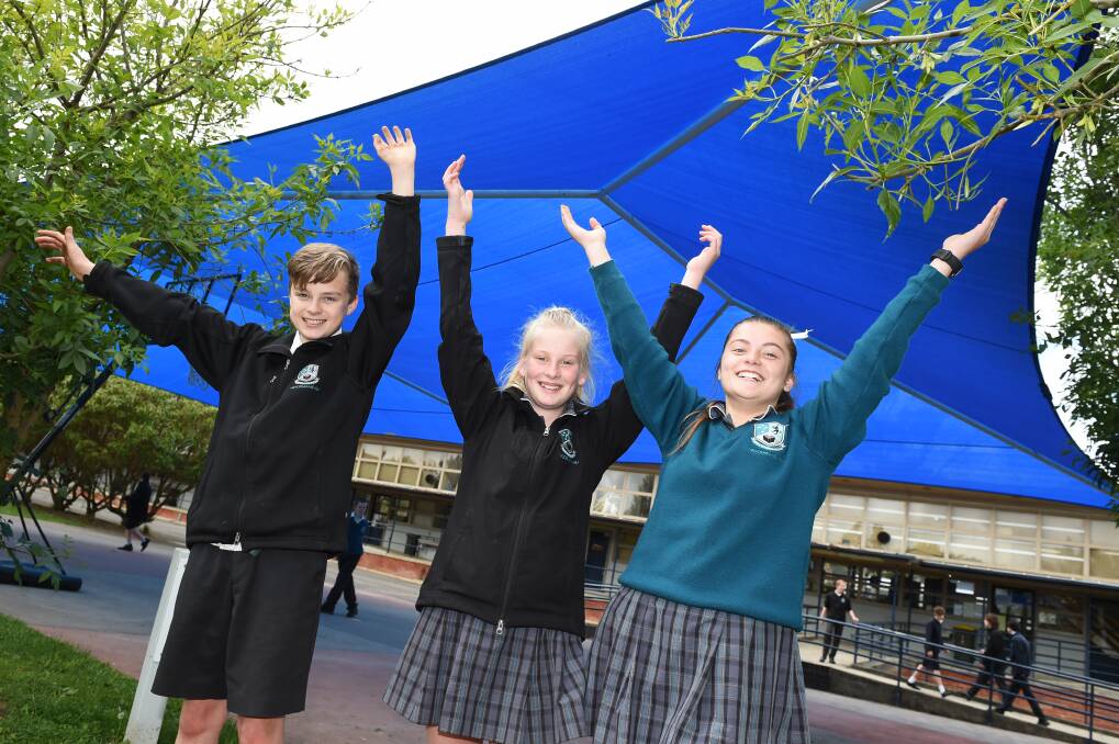 SUNSMART: Woodman's Hill year seven students Sam Hammett, Abbie Bride and Nykiah Tinetti welcome the new shade shelter. Picture: Kate Healy