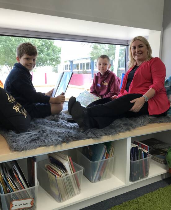 QUIET TIME: Delacombe Primary School pupils Rylan and Angus, 7, share a story-time in the reading nook of their new grade 1/2 classroom with Wendouree MP Sharon Knight. Picture: Michelle Smith. 