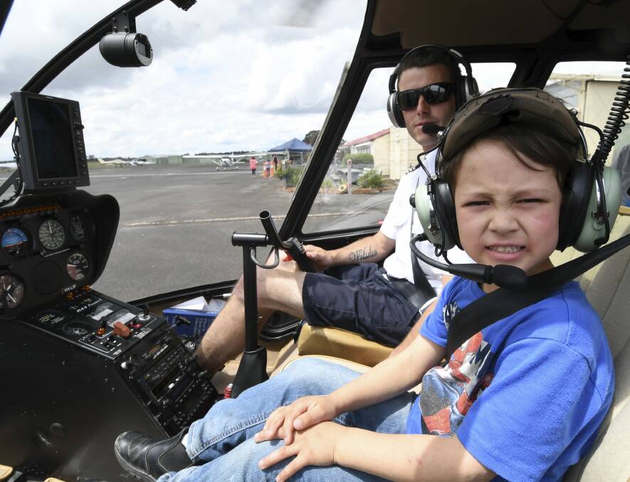 UP AND AWAY: Samuel, 7, takes a helicopter flight with Chad Wilsdon at Ballarat Airport as part of the four-day Cops 'n' Kids Camp in Ballarat. Picture: Lachlan Bence
